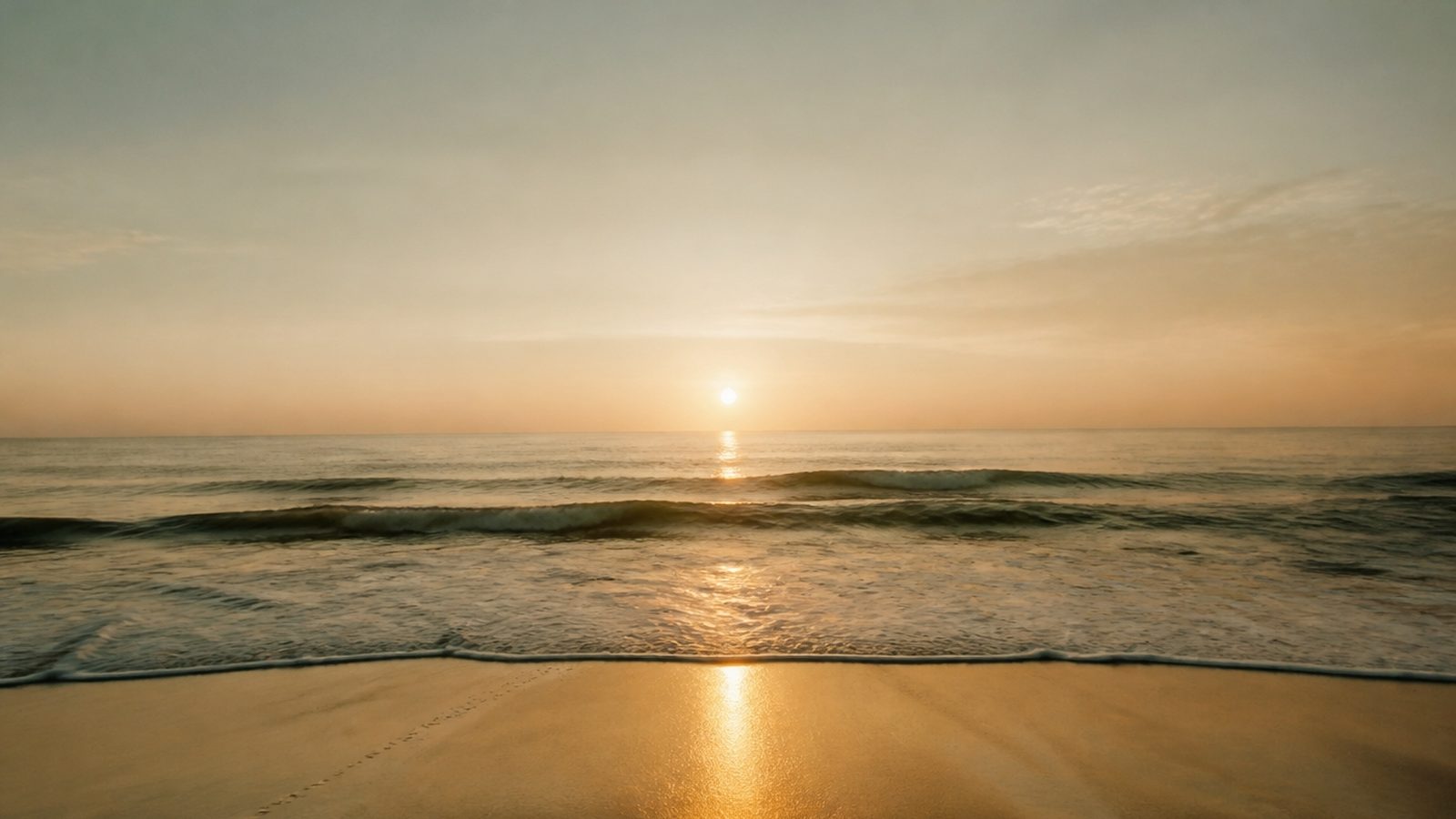 A calm ocean horizon at sunrise beneath a soft gradient sky
